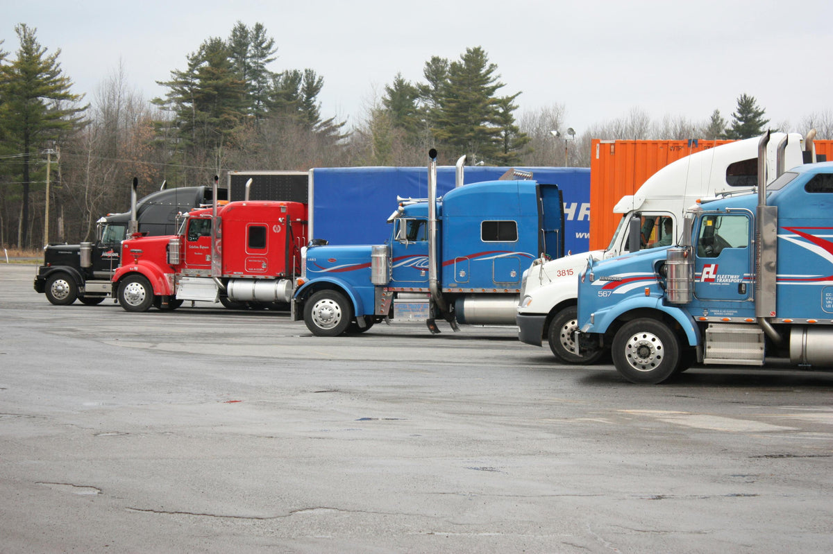 Colorful semi trucks parked in an open lot, fleet logistics