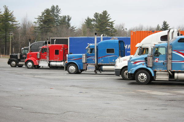 Colorful semi trucks parked in an open lot, fleet logistics